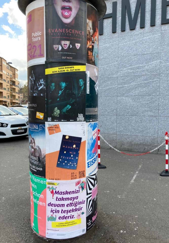 Affiche des neuen Romans «Während wir feiern» an einer Litfasssäule bei der Schmiede Wiedikon