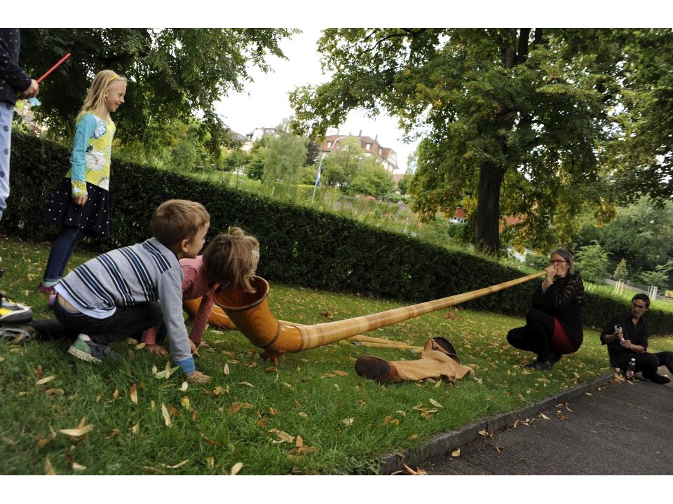 Kinder inspizieren ein Alphorn